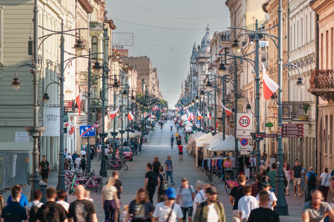 Вулиця Пйотрковська в Лодзі з прапорами, ліхтарями та перехожими