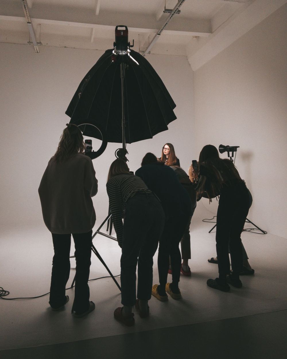 Ekipa fotografów pracuje w studiu z dużym parasolem oświetleniowym