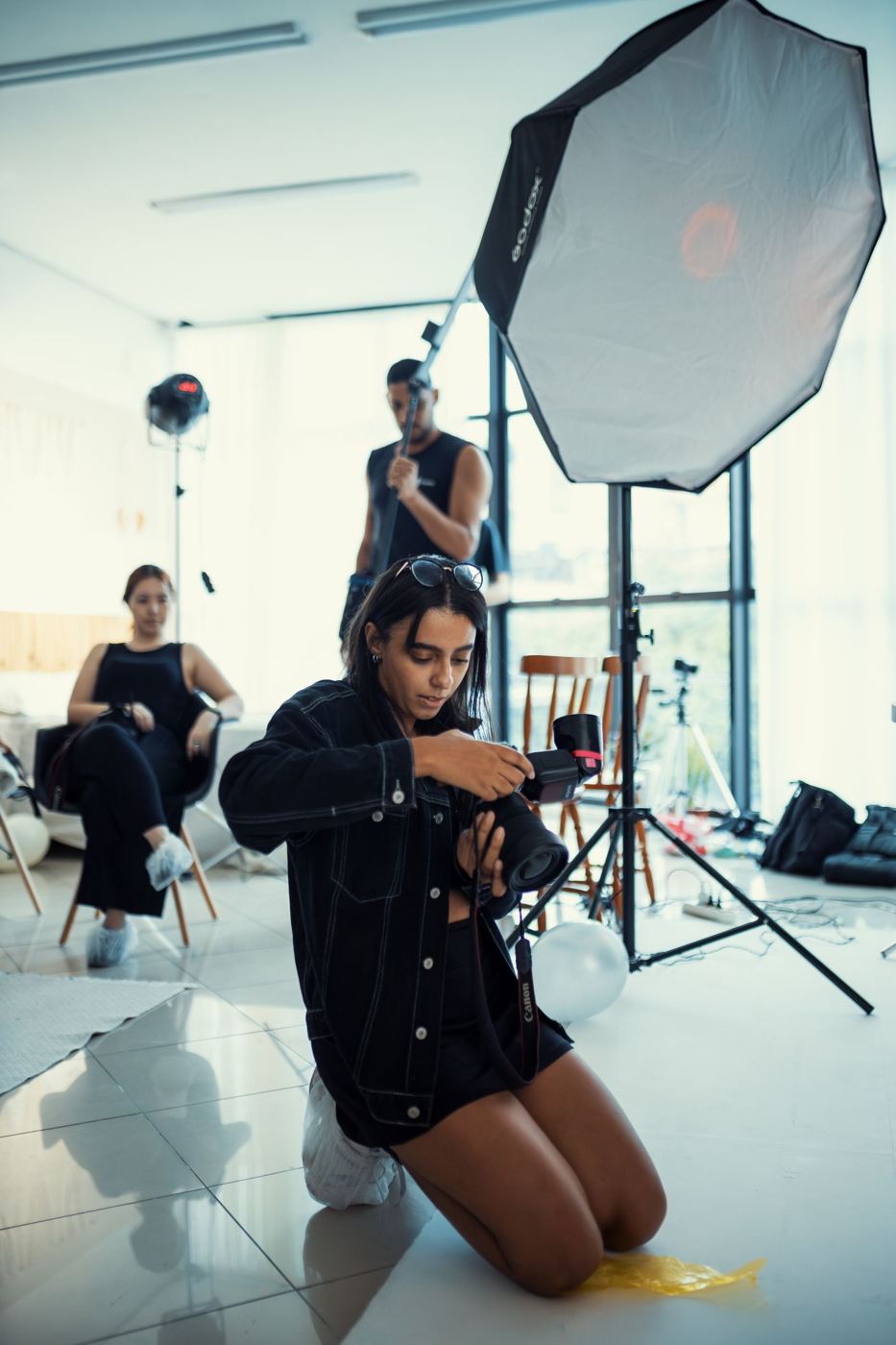 Fotografka przygotowuje sprzęt w jasnym studiu